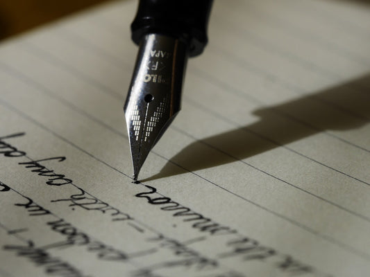 Person writing in notebook — importance of writing skills